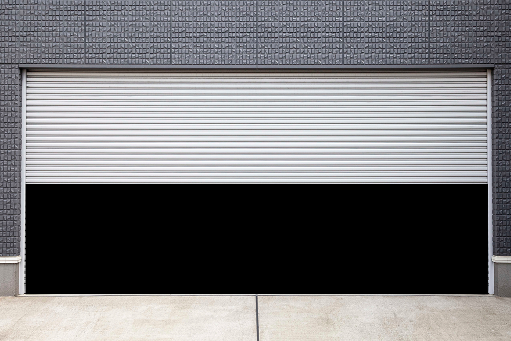 Homeowner using a tape measure to measure a garage door for a free repair or replacement estimate