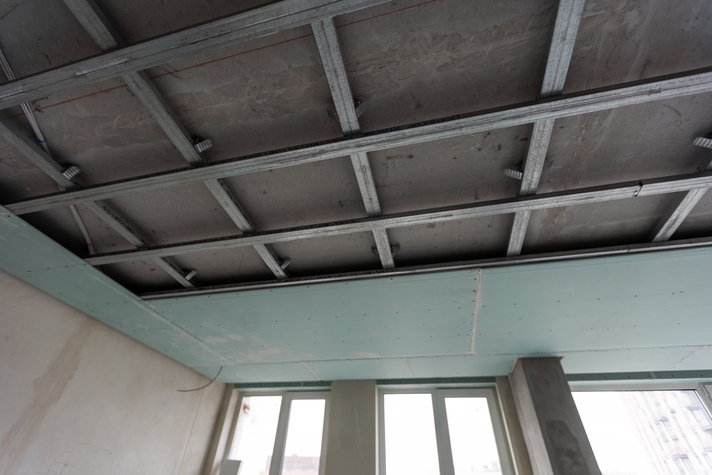 Damaged garage door panel being inspected for possible single panel replacement by a technician