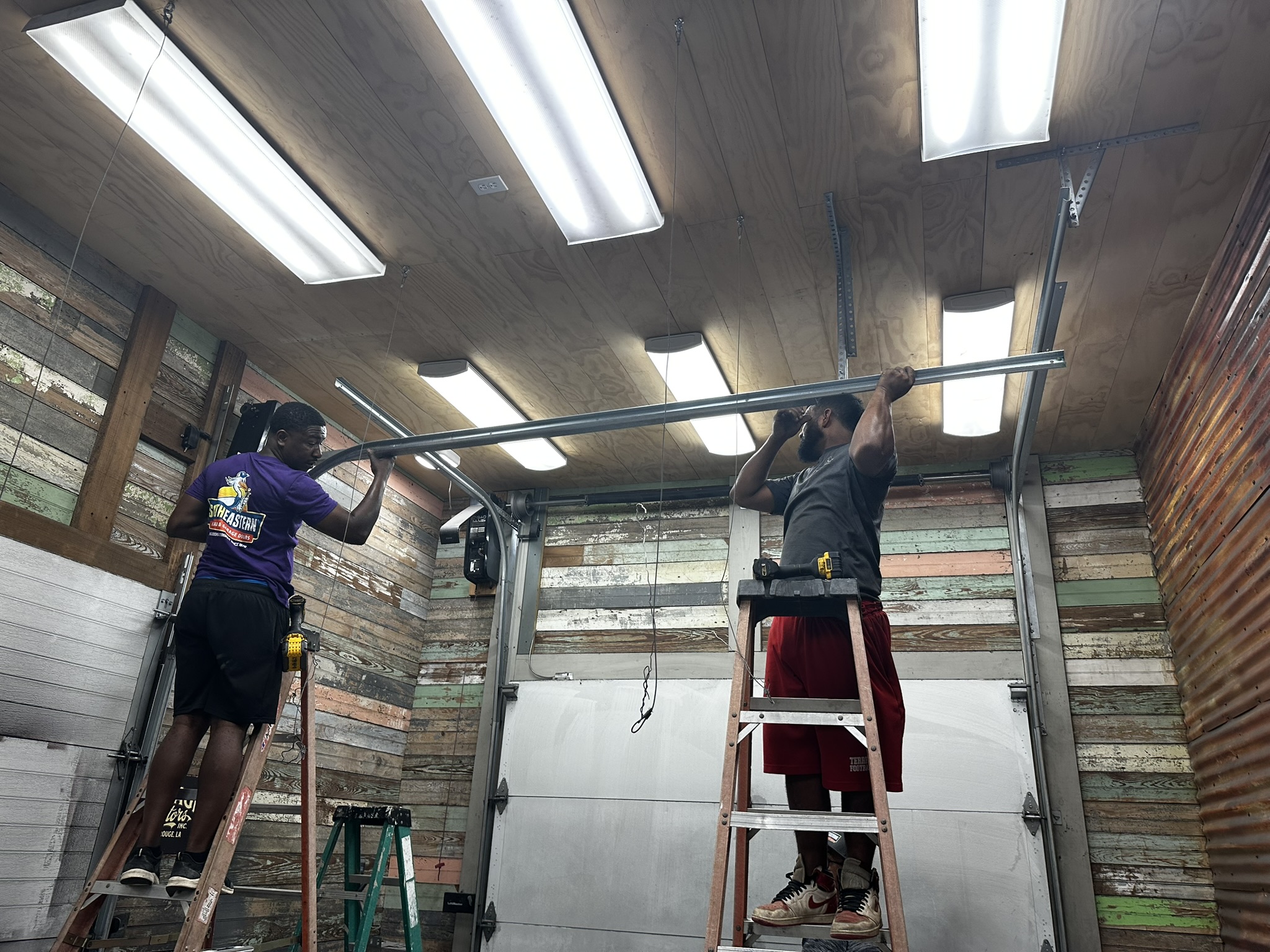 Technician inspecting dangerous garage door problems to ensure safe operation and prevent accidents